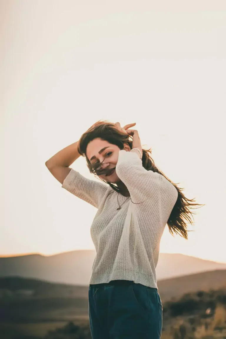 Smiling woman enjoying the sunset with a carefree attitude outdoors
