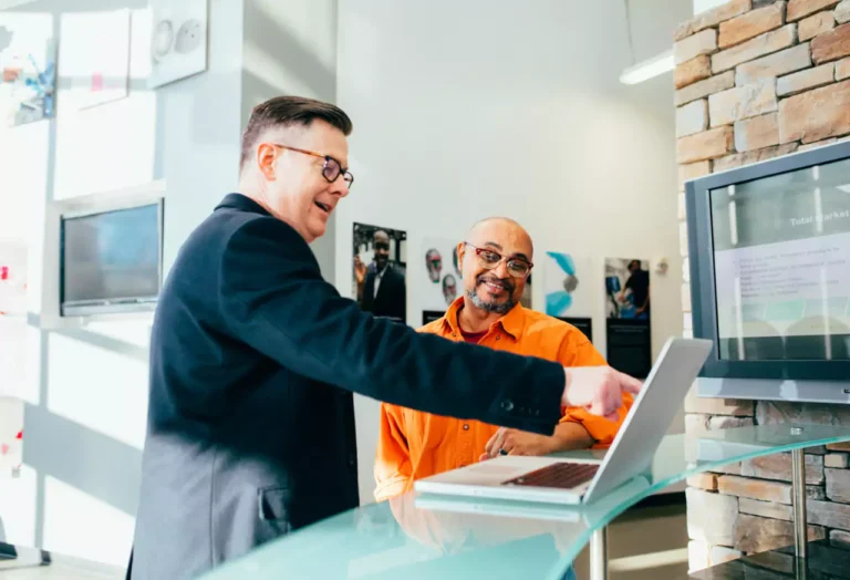 Happy men looking at a PC after solving their problems