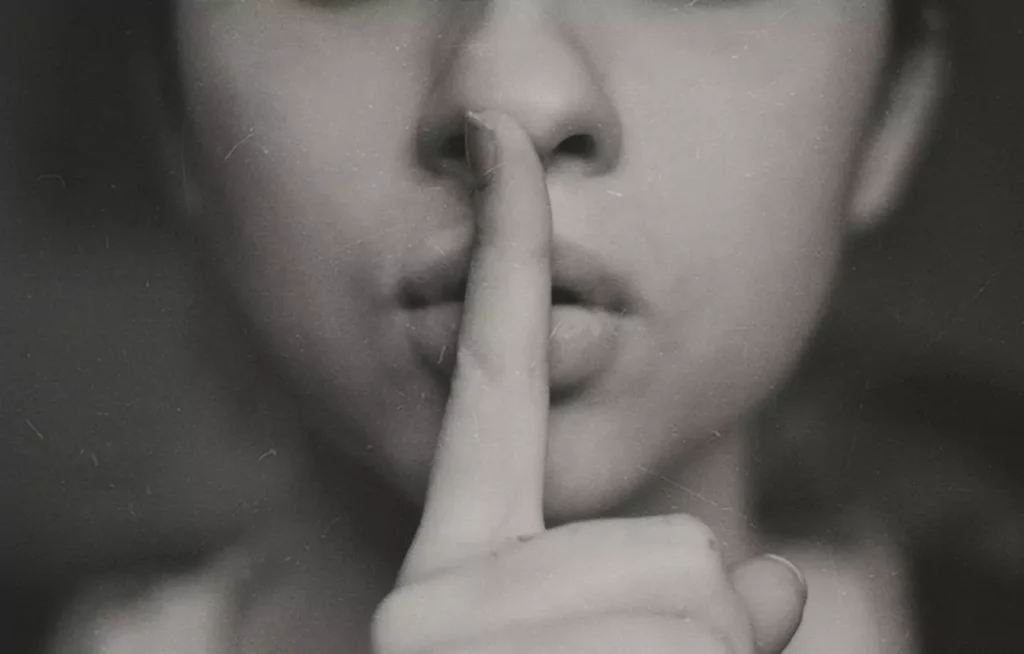 A woman hinting at keeping quiet