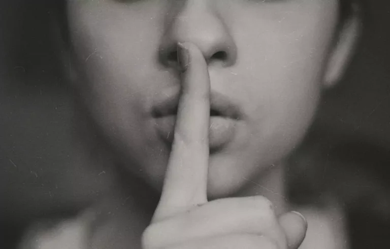 A woman hinting at keeping quiet