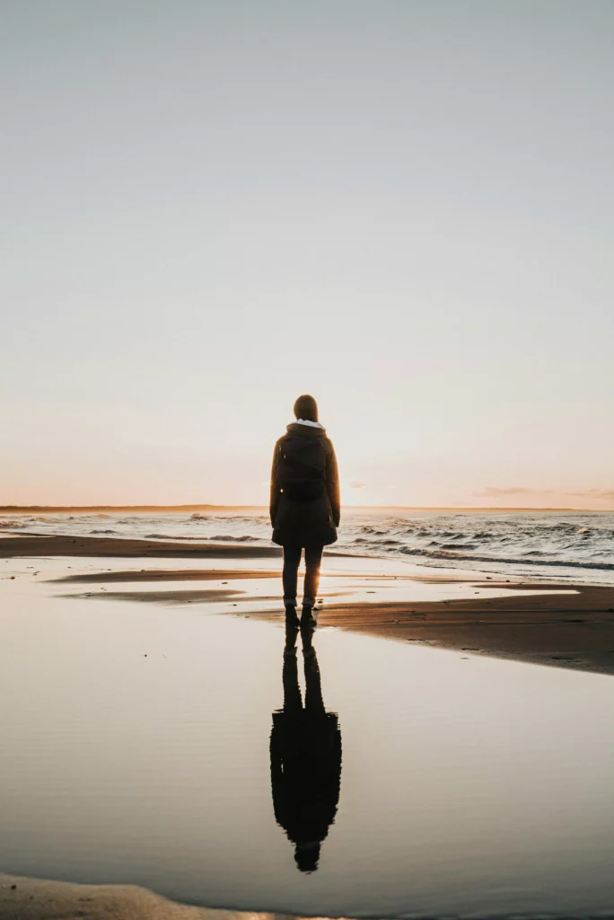 Woman reflecting facing an ocean
